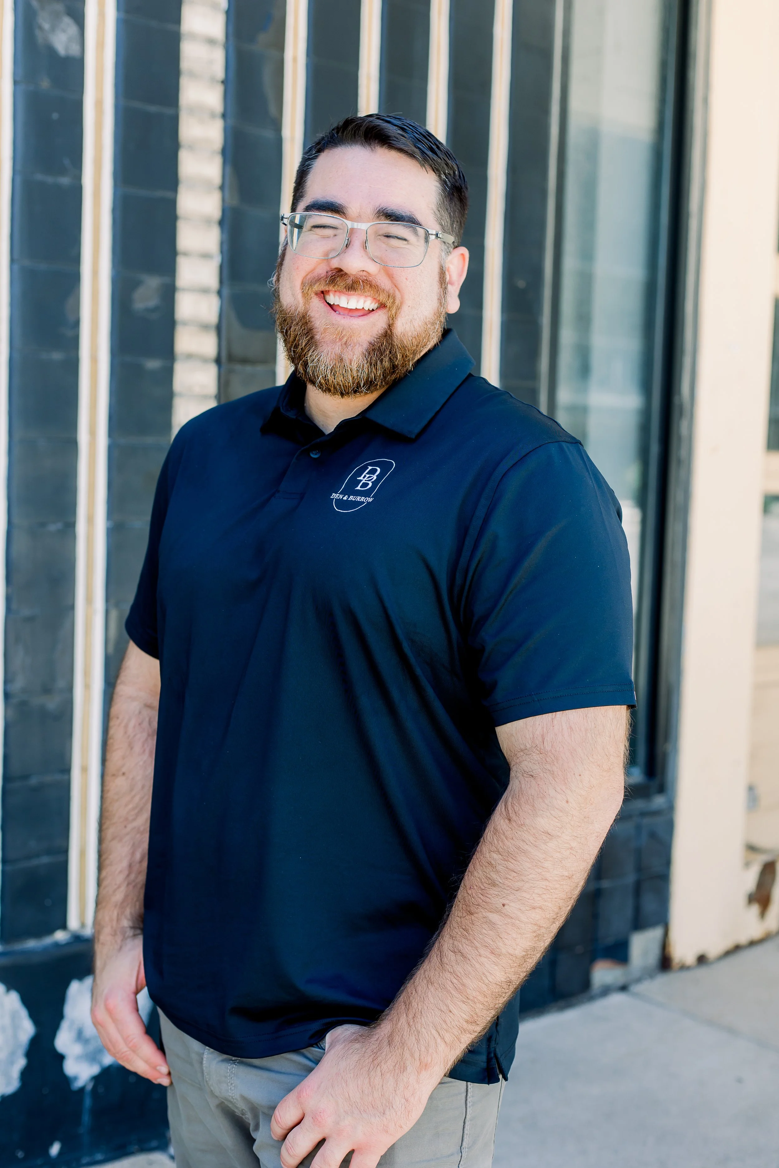 Alec Calzada, co-founder of Den & Burrow, outside in his company polo.